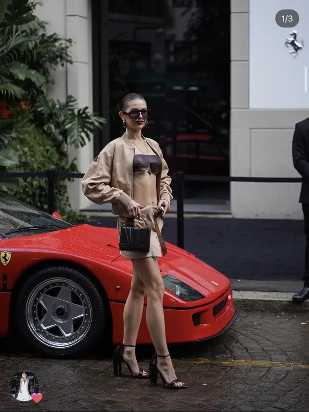 Уличный fashion-кадр рядом с красным автомобилем